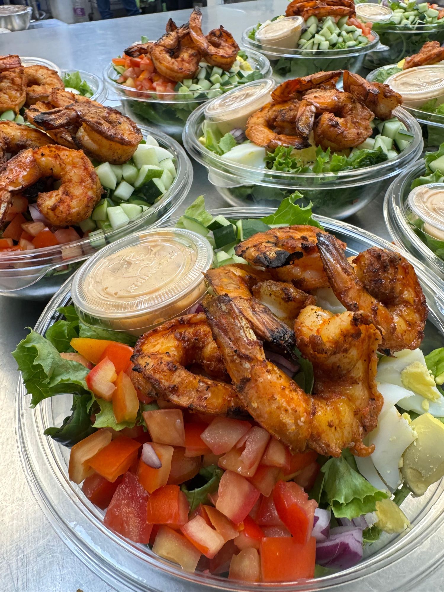 Rows of packed shrimp salad bowls prepared for the week ahead