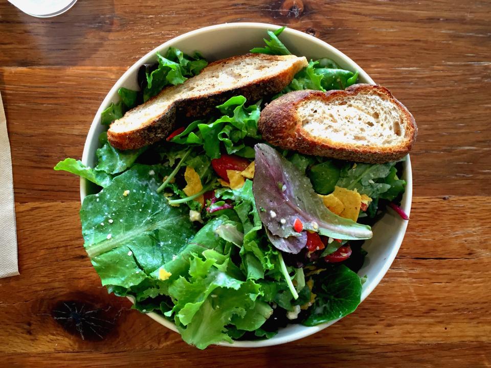 A generous fresh salad bowl with toasted bread — balanced, never boring